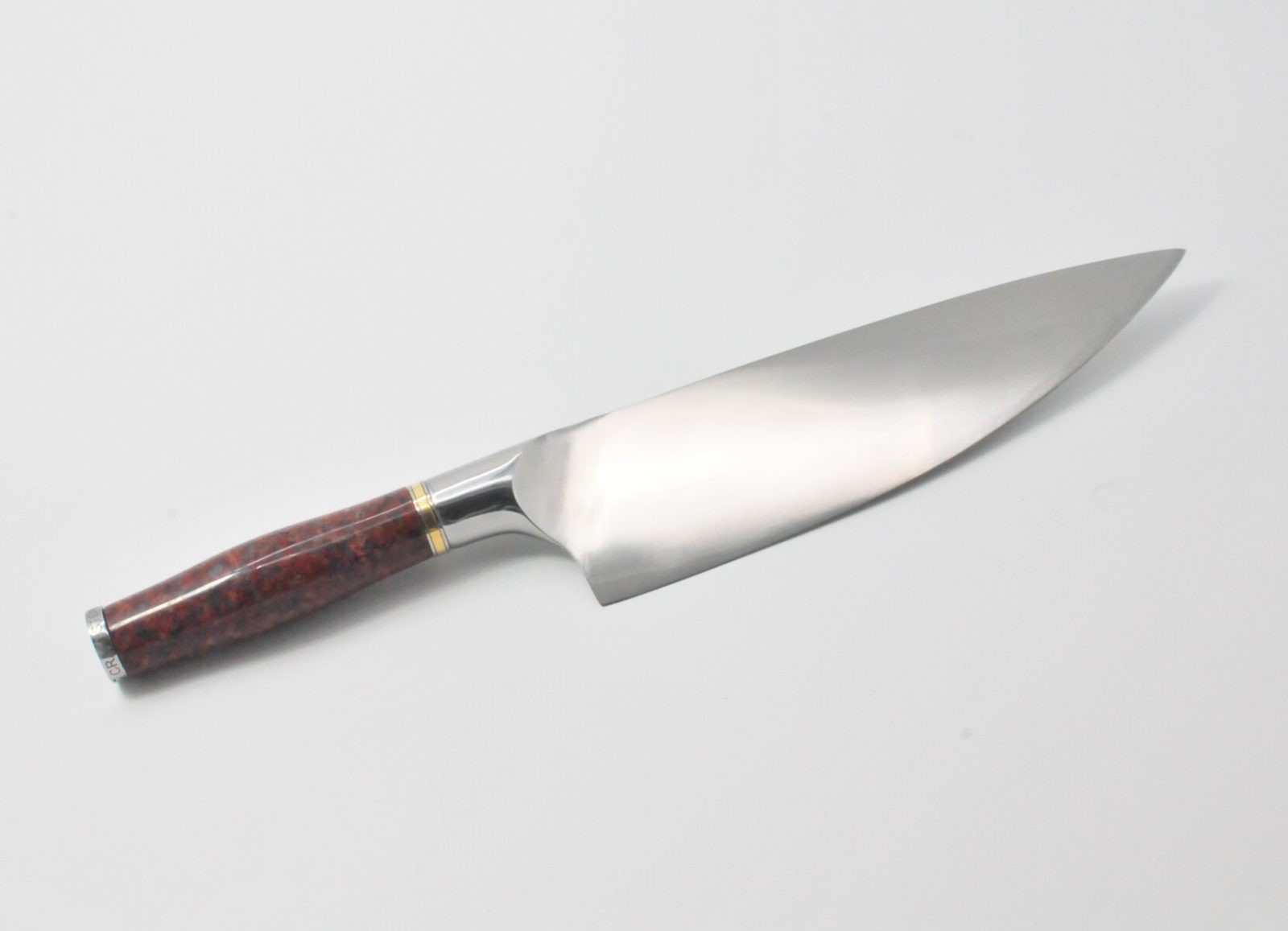 8 Inch Chef Knife with a Red Granite Handle, a Garnet Colored Cubic Zirconia Stone at the Back of the Knife and Brass and Stainless Steel Decorative Rings