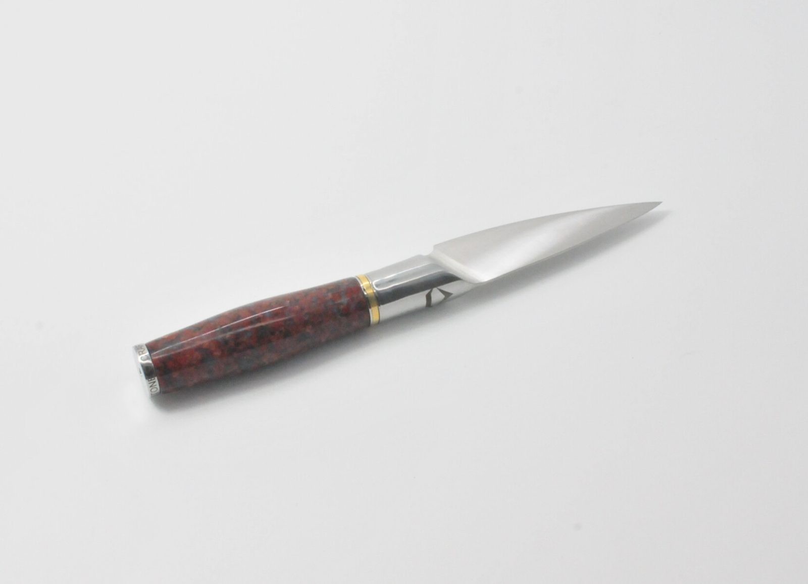 4 Inch Pairing Knife with a Red Granite Handle, a Garnet Colored Cubic Zirconia Stone at the Back of the Knife and Brass and Stainless Steel Decorative Rings