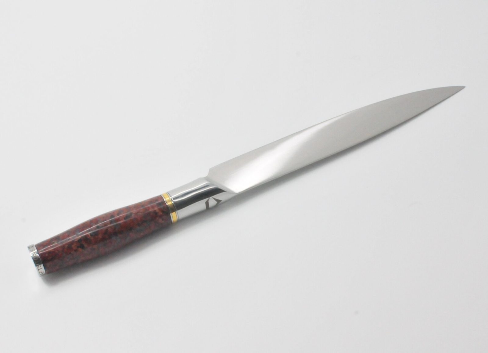 8 Inch Carving Knife with a Red Granite Handle, a Garnet Colored Cubic Zirconia Stone at the Back of the Knife and Brass and Stainless Steel Decorative Rings